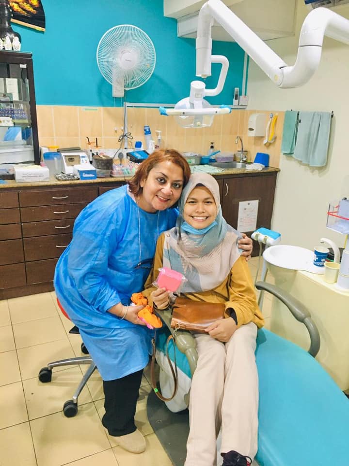Dr. Anantbir Kaur with a patient in the treatment room at Klinik Pergigian Setia