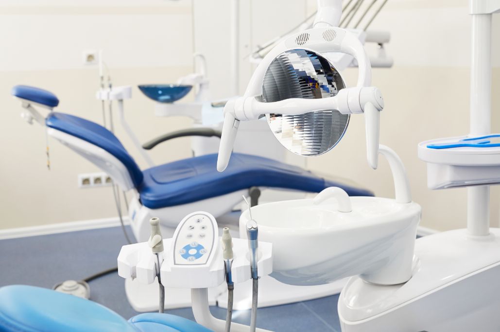 Dental chair, overhead lamp and handpieces in the surgery