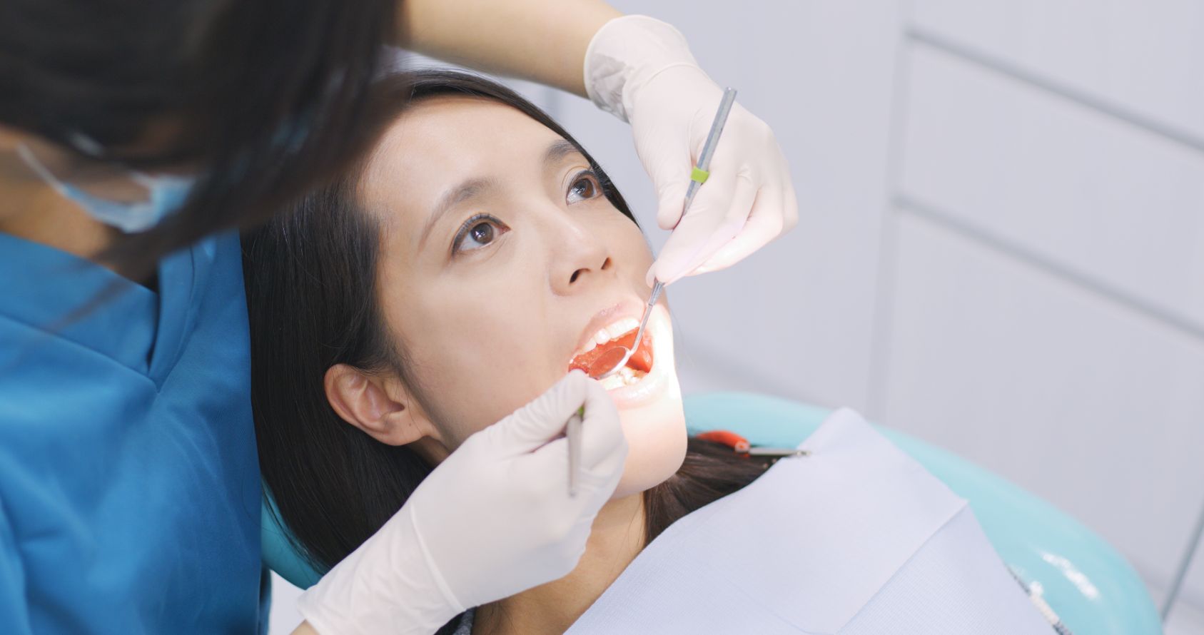 Dentist examining a patient's teeth with a mirror and probe